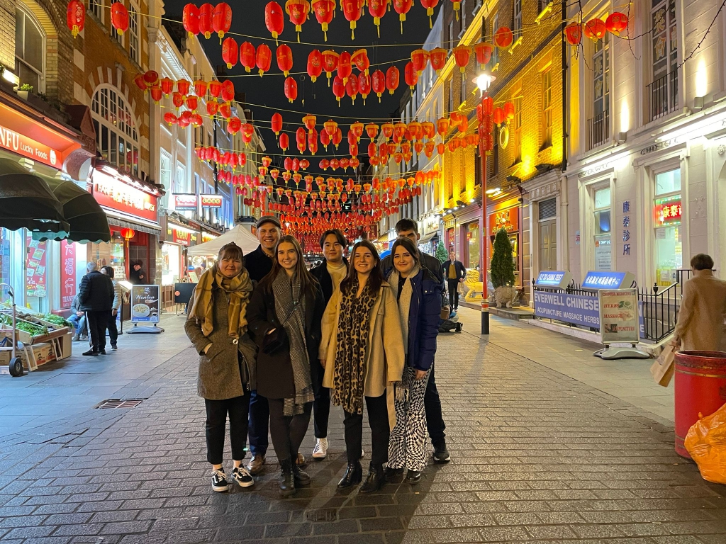 seven people standing on a street in Chinatown, London.