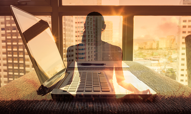 A silhouette of a woman in a yoga pose over a image of a laptop