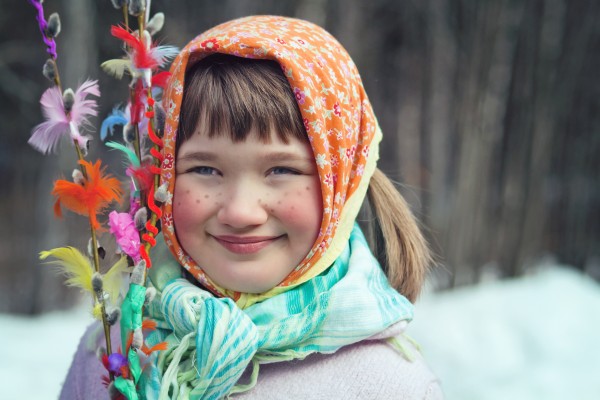 Girl dressed as an Easter witch with decorated willow branches