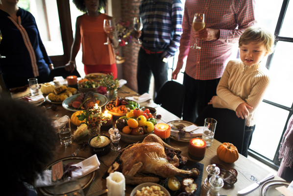 Family around Thanksgiving table including delicious turkey