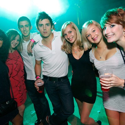 female-and-male-students-at-ball-drinking-and-posing-for-camera