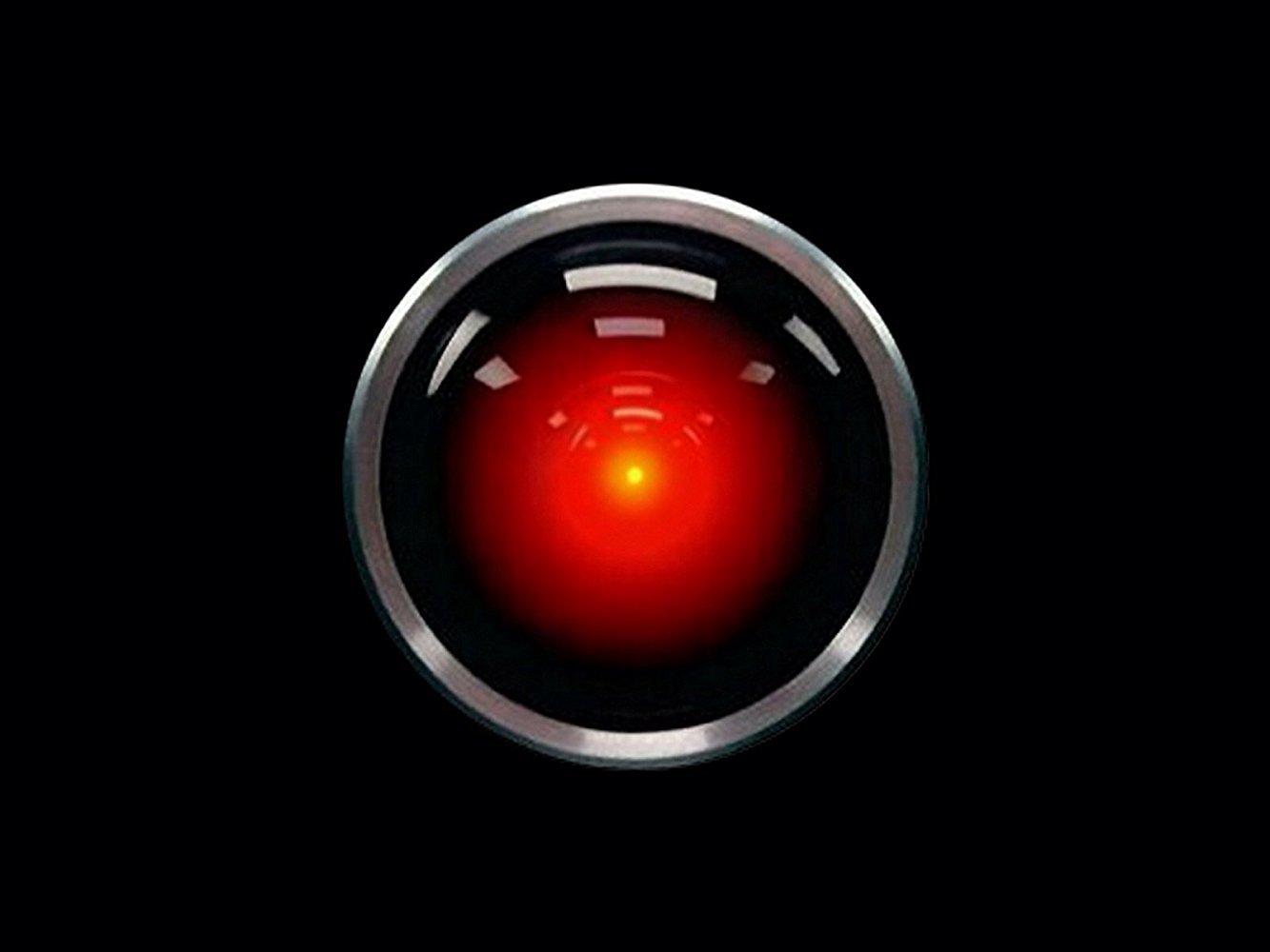 close-up picture of the camera of HAL from 2001: A Space Odyssey - a circle of silver with a red light inside it