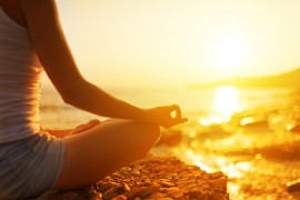 A woman meditating on a beach